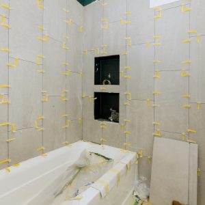 Laying tiles in the bathroom construction floor and wall ceramic tiles installation unfinished